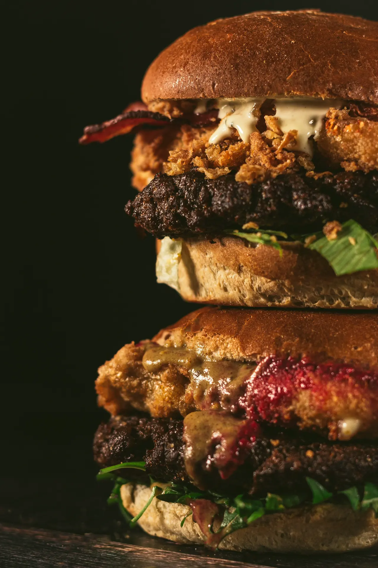 Close-up of stacked burgers on a dark background